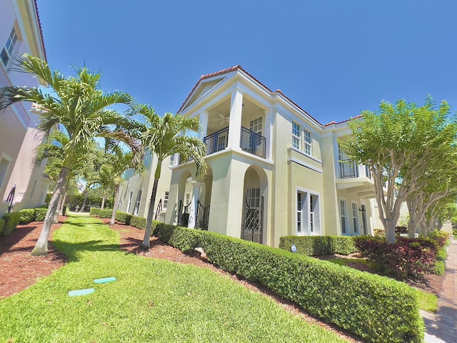 8300 NW 9th Ave, Boca Raton, FL 33487 - view of side of home featuring a balcony, a yard, stucco siding, and a ceiling fan