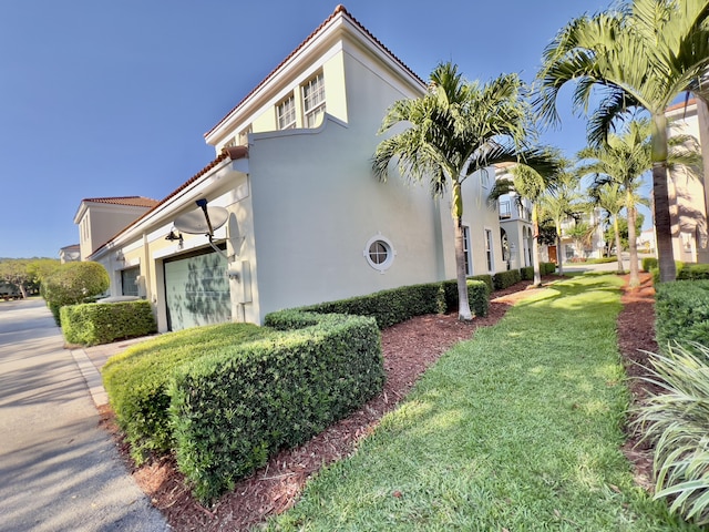 8300 NW 9th Ave, Boca Raton, FL 33487 - view of side of property featuring a garage, stucco siding, a tile roof, a lawn, and driveway