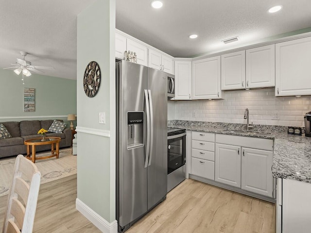 2800 Indian River Blvd Unit J6, Vero Beach, FL 32960 - kitchen featuring appliances with stainless steel finishes, light wood-style flooring, ceiling fan, white cabinetry, and a textured ceiling