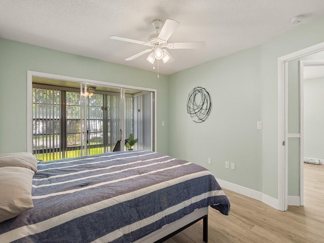 2800 Indian River Blvd Unit J6, Vero Beach, FL 32960 - bedroom featuring light wood finished floors, access to outside, ceiling fan, and a textured ceiling