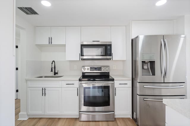 88 3rd St, West Palm Beach, FL 33413 - kitchen featuring appliances with stainless steel finishes, a sink, light countertops, white cabinetry, and recessed lighting