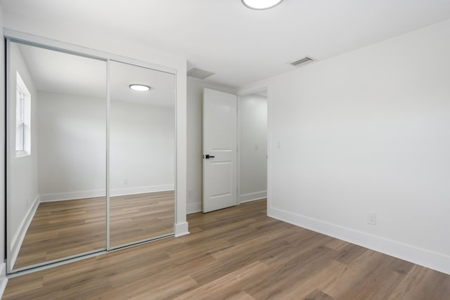 88 3rd St, West Palm Beach, FL 33413 - unfurnished bedroom with wood finished floors, baseboards, and a closet