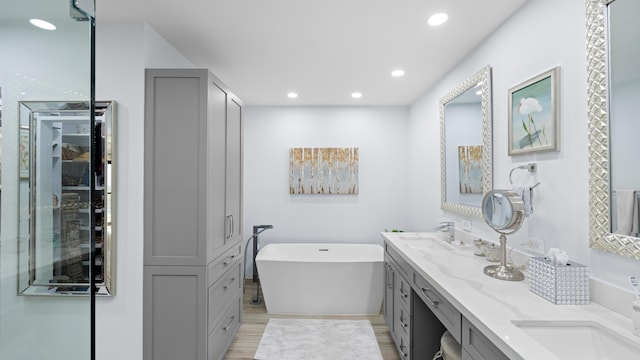 21415 Campo Allegro Dr, Boca Raton, FL 33433 - bathroom featuring double vanity, a freestanding bath, recessed lighting, and wood finished floors
