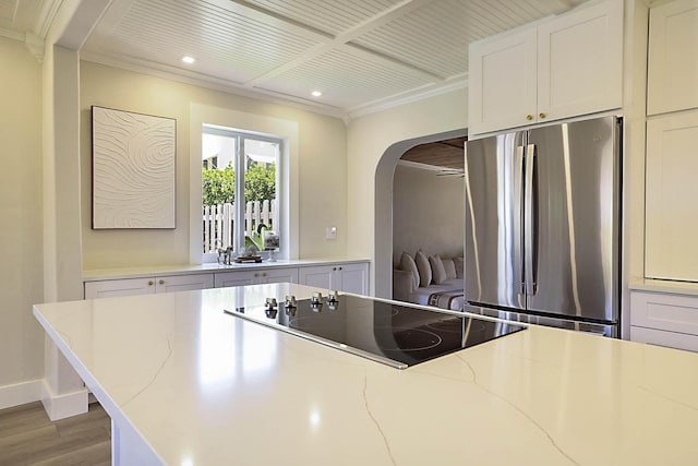 1630 N Ocean Breeze, Lake Worth Beach, FL 33460 - kitchen featuring freestanding refrigerator, black electric cooktop, arched walkways, wood finished floors, and recessed lighting