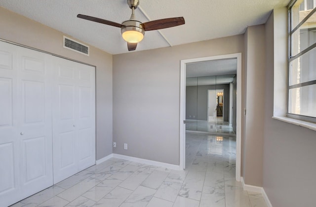 5500 NW 2nd Ave Three, Unit Three, Boca Raton, FL 33487 - unfurnished bedroom featuring light marble finish floors, a textured ceiling, baseboards, a closet, and a ceiling fan