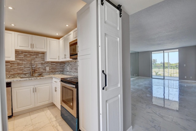 5500 NW 2nd Ave Three, Unit Three, Boca Raton, FL 33487 - kitchen with appliances with stainless steel finishes, light marble finish floors, a sink, white cabinetry, and light stone counters