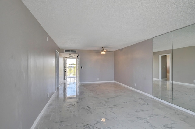 5500 NW 2nd Ave Three, Unit Three, Boca Raton, FL 33487 - spare room featuring a textured ceiling, a ceiling fan, light marble finish floors, and baseboards
