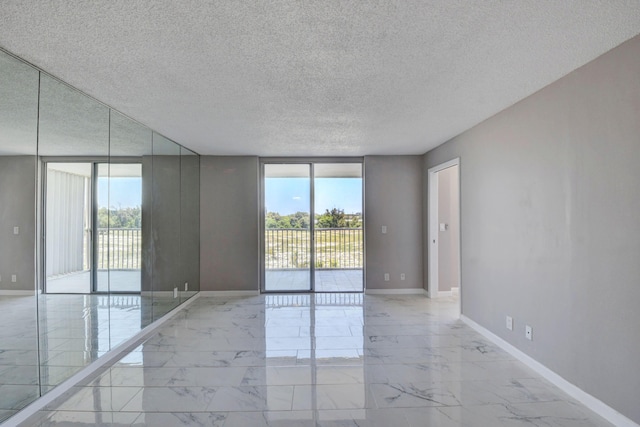 5500 NW 2nd Ave Three, Unit Three, Boca Raton, FL 33487 - empty room featuring light marble finish floors, a textured ceiling, and baseboards