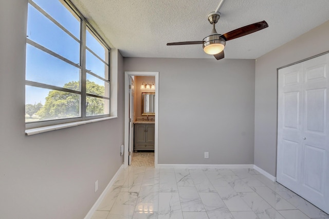 5500 NW 2nd Ave Three, Unit Three, Boca Raton, FL 33487 - unfurnished bedroom with light marble finish flooring, baseboards, a textured ceiling, a ceiling fan, and ensuite bath