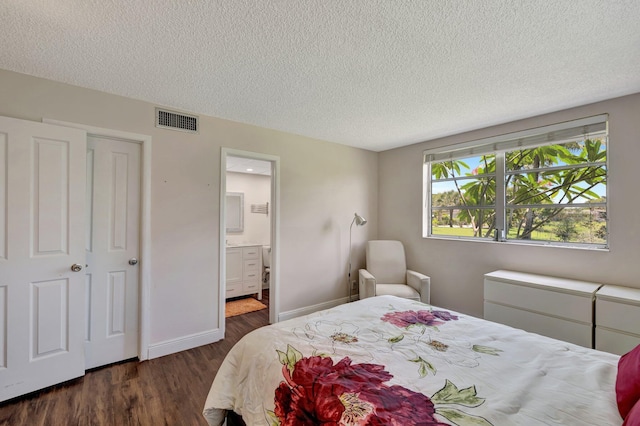 2901 NW 46th Ave Unit 101, Lauderdale Lakes, FL 33313 - bedroom with a textured ceiling, dark wood-style floors, and ensuite bath