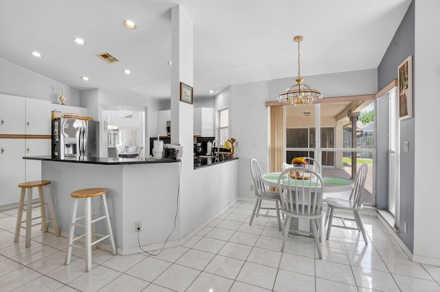 9645 Carousel Cir N, Boca Raton, FL 33434 - kitchen with stainless steel refrigerator with ice dispenser, a chandelier, white cabinetry, dark countertops, and light tile patterned flooring
