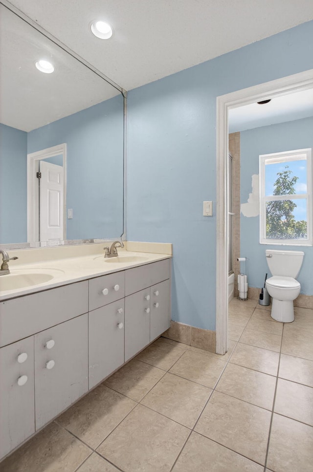 9645 Carousel Cir N, Boca Raton, FL 33434 - bathroom with double vanity, toilet, tile patterned flooring, recessed lighting, and bath / shower combo with glass door