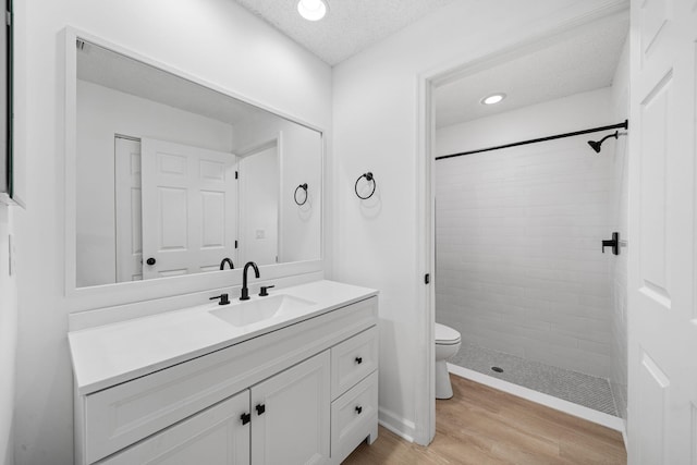 17832 43rd Rd N, Loxahatchee, FL 33470 - full bath with vanity, a tile shower, toilet, wood finished floors, and a textured ceiling
