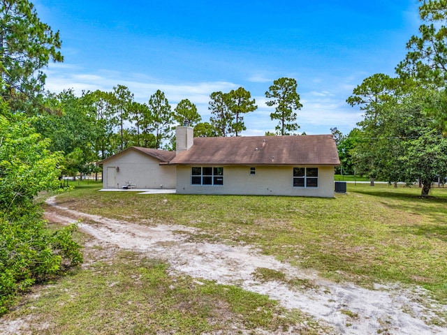 17832 43rd Rd N, Loxahatchee, FL 33470 - rear view of house with a chimney, a yard, driveway, and central air condition unit