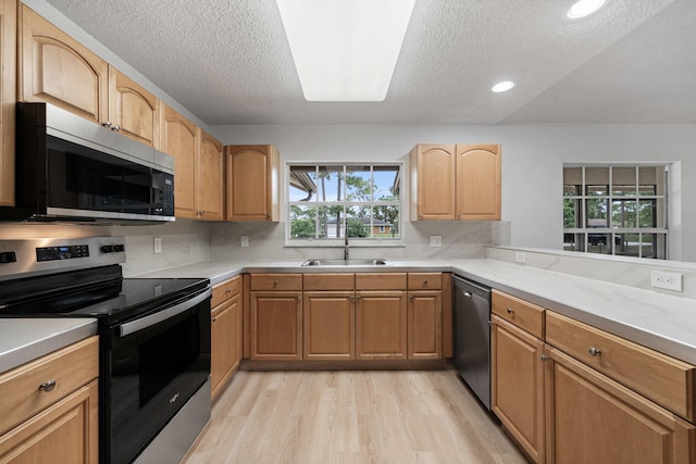 17832 43rd Rd N, Loxahatchee, FL 33470 - kitchen featuring stainless steel appliances, a sink, a textured ceiling, light wood-style flooring, and light countertops