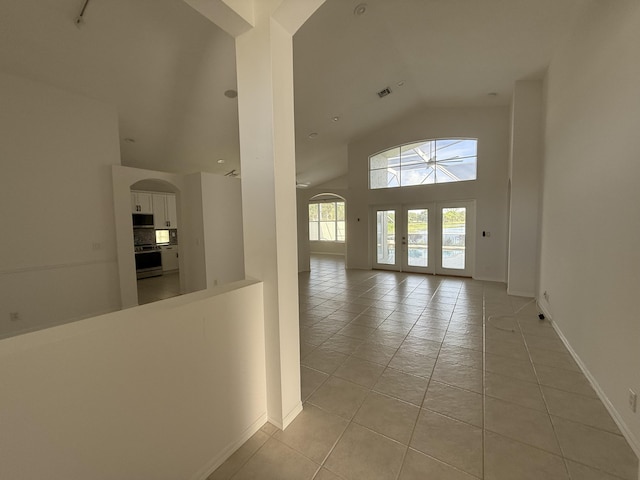 9360 Cove Point Cir, Boynton Beach, FL 33472 - hall featuring light tile patterned floors, high vaulted ceiling, arched walkways, and french doors