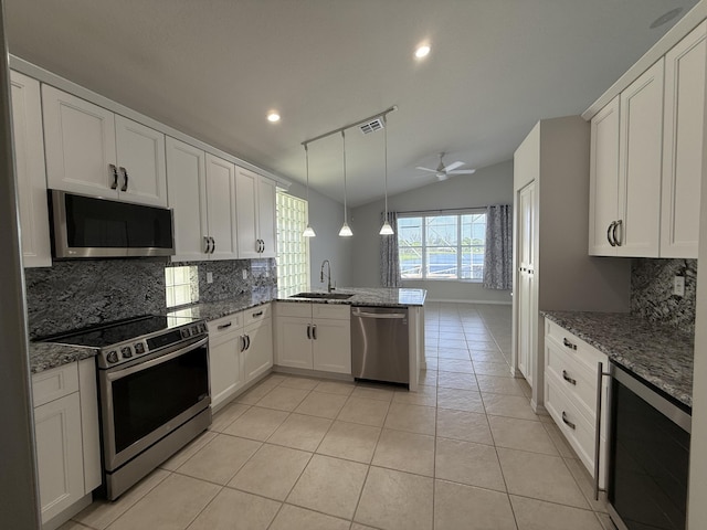9360 Cove Point Cir, Boynton Beach, FL 33472 - kitchen with appliances with stainless steel finishes, beverage cooler, a peninsula, decorative backsplash, and light tile patterned flooring