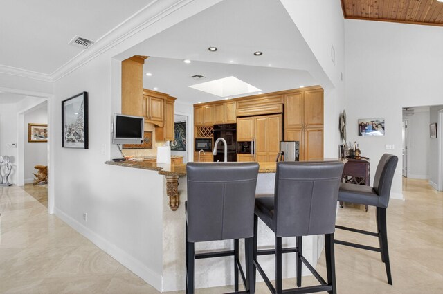3765 Canterbury Ct, Boca Raton, FL 33434 - kitchen with paneled refrigerator, a peninsula, black microwave, a skylight, and a kitchen bar