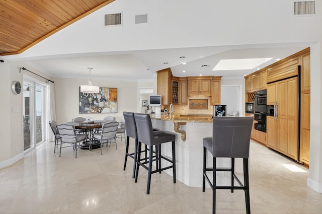 3765 Canterbury Ct, Boca Raton, FL 33434 - kitchen with paneled built in refrigerator, a kitchen bar, light stone counters, glass insert cabinets, and a peninsula