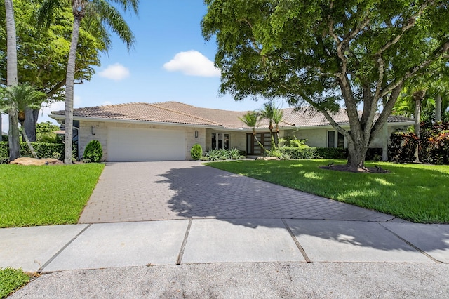 3765 Canterbury Ct, Boca Raton, FL 33434 - single story home with a tile roof, an attached garage, decorative driveway, a front lawn, and stone siding