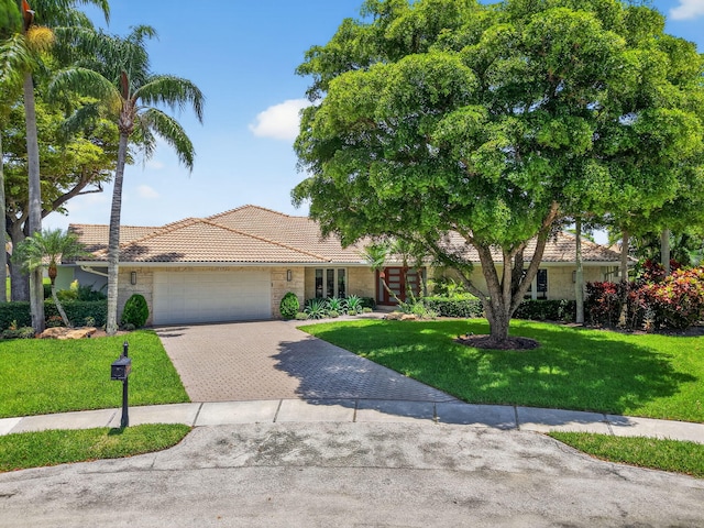 3765 Canterbury Ct, Boca Raton, FL 33434 - single story home featuring a tile roof, an attached garage, a front lawn, and driveway