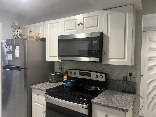 3099 NW 48th Ave Unit 163, Lauderdale Lakes, FL 33313 - kitchen with appliances with stainless steel finishes, decorative backsplash, and white cabinetry