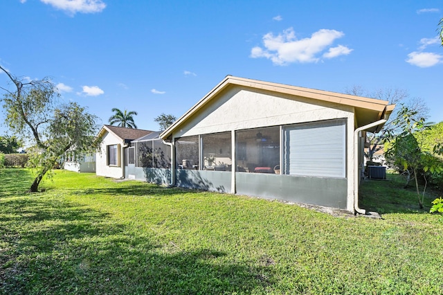 2850 NW 15th St, Delray Beach, FL 33445 - view of home's exterior with a yard, a sunroom, and central AC