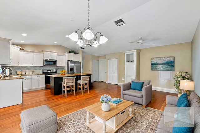 2850 NW 15th St, Delray Beach, FL 33445 - living area with vaulted ceiling, light wood-type flooring, a ceiling fan, a chandelier, and recessed lighting