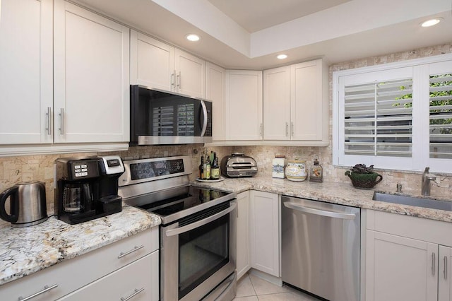 157 Capri D, Delray Beach, FL 33484 - kitchen featuring stainless steel appliances, decorative backsplash, white cabinets, recessed lighting, and light stone counters