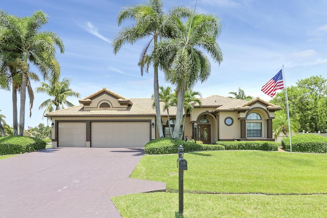 3429 SW Catskill Dr, Port Saint Lucie, FL 34953 - mediterranean / spanish-style home with an attached garage, stucco siding, concrete driveway, a front yard, and a tiled roof