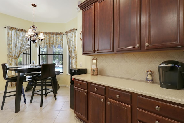 3429 SW Catskill Dr, Port Saint Lucie, FL 34953 - kitchen featuring a chandelier, light countertops, decorative backsplash, decorative light fixtures, and light tile patterned floors