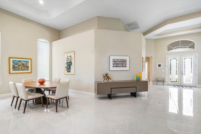 391 Isle Ct, Palm Beach Gardens, FL 33418 - dining area with a raised ceiling, french doors, a high ceiling, and light marble finish floors