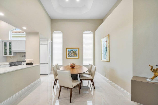 391 Isle Ct, Palm Beach Gardens, FL 33418 - dining space with recessed lighting, a tray ceiling, and light tile patterned flooring