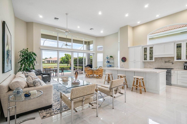 391 Isle Ct, Palm Beach Gardens, FL 33418 - living room featuring a towering ceiling, recessed lighting, and ceiling fan