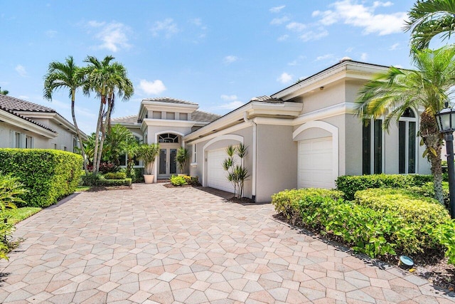391 Isle Ct, Palm Beach Gardens, FL 33418 - mediterranean / spanish-style house featuring stucco siding, a garage, and decorative driveway