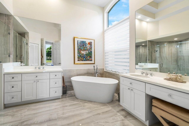 391 Isle Ct, Palm Beach Gardens, FL 33418 - full bathroom featuring a stall shower, two vanities, a freestanding bath, tile walls, and a towering ceiling