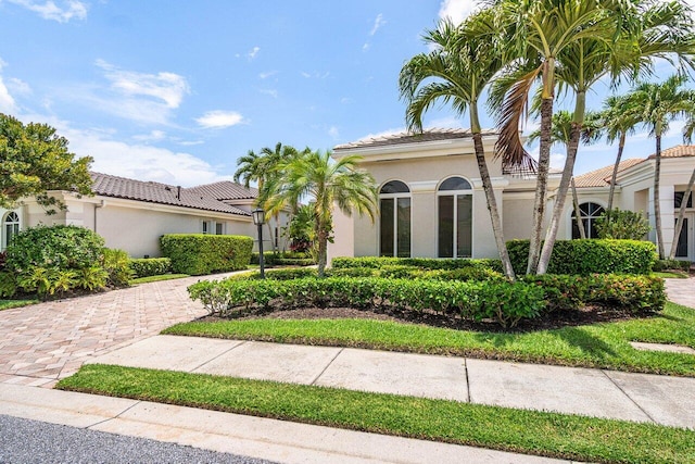 391 Isle Ct, Palm Beach Gardens, FL 33418 - mediterranean / spanish-style house featuring stucco siding, a tile roof, and decorative driveway