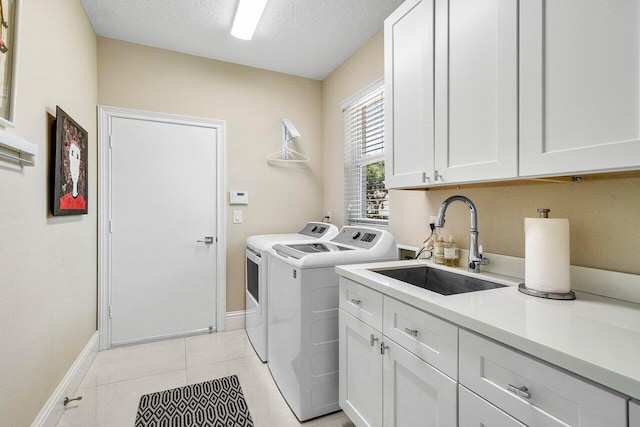 391 Isle Ct, Palm Beach Gardens, FL 33418 - laundry area featuring cabinet space, washer and clothes dryer, a textured ceiling, and light tile patterned flooring