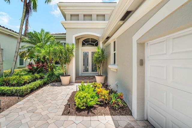 391 Isle Ct, Palm Beach Gardens, FL 33418 - property entrance with stucco siding and an attached garage