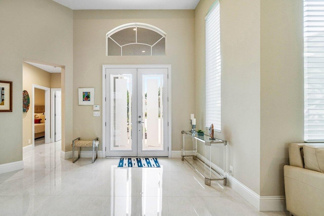 391 Isle Ct, Palm Beach Gardens, FL 33418 - entrance foyer featuring french doors, light tile patterned flooring, and a towering ceiling