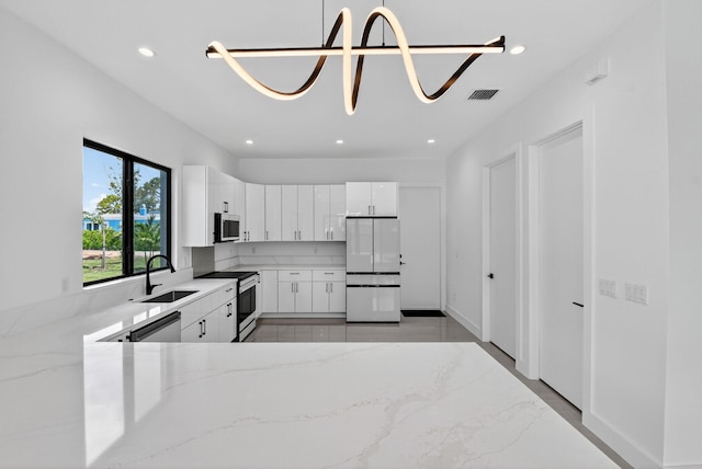 3920 Espan Ct, Palm Springs, FL 33461 - kitchen featuring stainless steel appliances, light stone countertops, recessed lighting, white cabinetry, and light marble finish floors