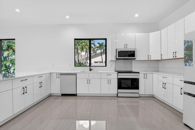 3920 Espan Ct, Palm Springs, FL 33461 - kitchen with stainless steel electric range oven, dishwashing machine, light countertops, recessed lighting, and white cabinetry