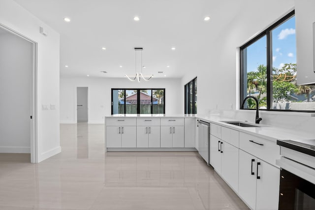 3920 Espan Ct, Palm Springs, FL 33461 - kitchen with dishwasher, recessed lighting, white cabinets, light countertops, and a peninsula