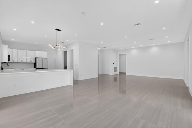 3920 Espan Ct, Palm Springs, FL 33461 - unfurnished living room with recessed lighting and a chandelier