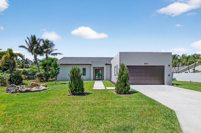3920 Espan Ct, Palm Springs, FL 33461 - view of front facade featuring an attached garage, concrete driveway, stucco siding, a front lawn, and french doors
