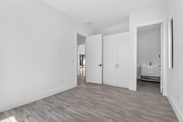 3920 Espan Ct, Palm Springs, FL 33461 - unfurnished bedroom with wood finished floors and connected bathroom