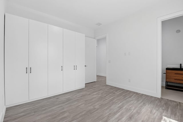 3920 Espan Ct, Palm Springs, FL 33461 - unfurnished bedroom featuring light wood-style floors and baseboards