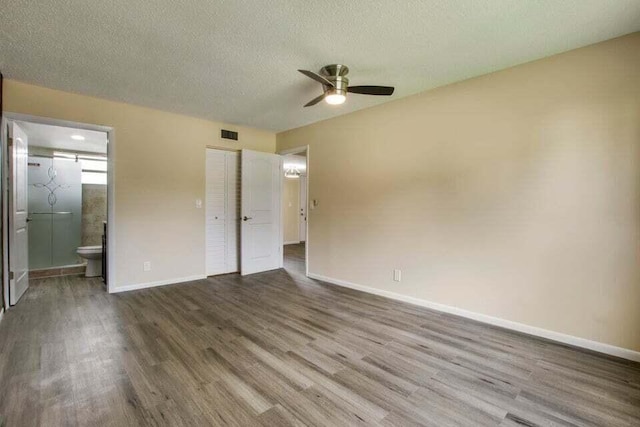 705 Lori Dr Unit 104, Palm Springs, FL 33461 - unfurnished bedroom featuring wood finished floors, baseboards, ensuite bath, a textured ceiling, and ceiling fan