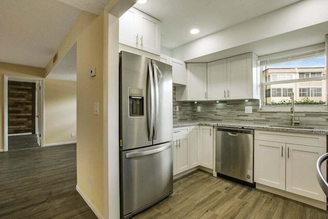 705 Lori Dr Unit 104, Palm Springs, FL 33461 - kitchen featuring appliances with stainless steel finishes, baseboards, a sink, dark wood-style flooring, and backsplash