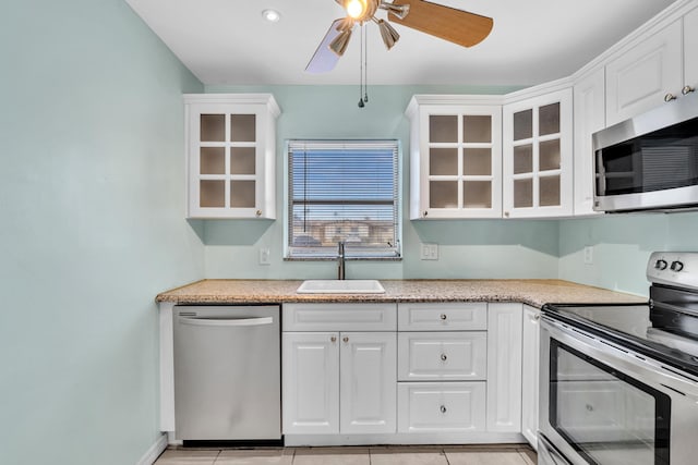 2765 Ashley Dr W Unit C, West Palm Beach, FL 33415 - kitchen featuring appliances with stainless steel finishes, a ceiling fan, white cabinets, and glass insert cabinets